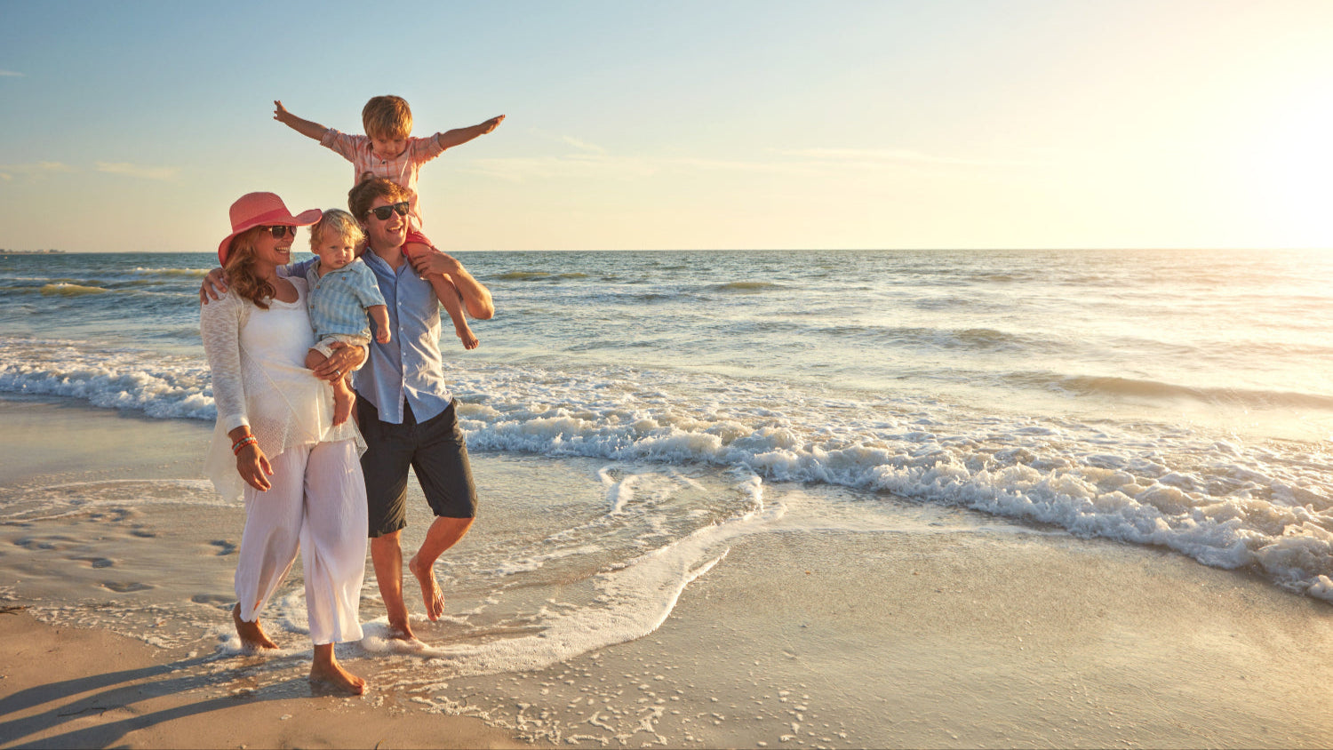 Happy family relaxing on the beach under a colorful umbrella with beach toys and chairs, showcasing 30A Beach Babies’ rental gear in action along Florida’s Scenic 30A.